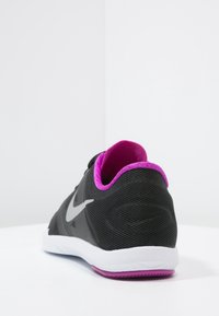 Scarpa sportiva nera con marchio grigio e interno rosa, mostrata in un'angolazione su uno sfondo bianco.