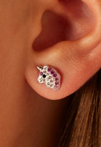 Zilveren oorbel in de vorm van een eenhoorn, versierd met heldere en roze rhinestones, met een witte basis en een klein hoornontwerp.