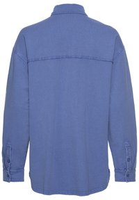 Camisa de manga larga azul hecha de mezcla de algodón, con un cuello clásico, puños abotonados y corte recto, con una textura suave.