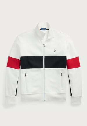 Chaqueta blanca con cierre y cuello alzado. Presenta franjas horizontales rojas y negras en el pecho y las mangas. Dos bolsillos laterales con cremallera.