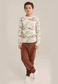 Långärmad pyjamaströja i crème med grön palm- och orange solnedgångsmönster, tillsammans med bruna långbyxor. Mjuk bomullsmaterial, avslappnad passform.