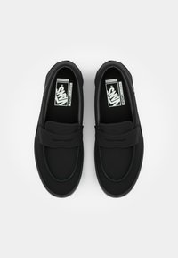 Sorte slip-on sko med en glatt, teksturert overflate, med stikkede detaljer og en polstret innersåle. Klassisk Vans-logo på innersålen.
