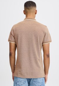 Brown short-sleeve polo shirt with a textured fabric, featuring a light beige collar and cuffs, and a straight hem.