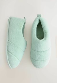 Mint green, plush slippers with a rounded shape, a textured surface, and subtle stitching details. Each has a soft interior lining.