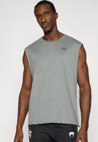 Γκρι αμάνικο μπλουζάκι από απαλό ύφασμα, με λαιμόκοψη crew και μικρό λογότυπο τυπωμένο στο στήθος. Ομαλή υφή, άνετη εφαρμογή.