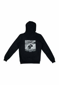 Musta huppari, jossa on kontrastivärinen valkoinen graafinen kuva takana, esittäen kuvitetun maiseman neliökehyksessä.