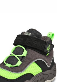 Schwarz-graue Sportschuhe mit neon-grünen Textilakzenten, verstellbarem Riemen, elastischen Schnürsenkeln und strukturierten Materialien für Langlebigkeit.