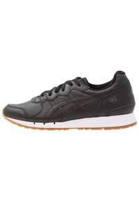 Black athletic shoes with leather upper, lace closure, cushioned collar, and white EVA midsole. Features a gum rubber outsole.