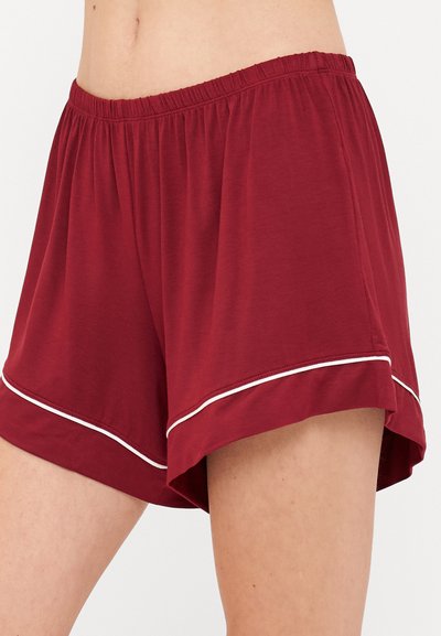 Μπορντό σορτς από μαλακό ύφασμα, με ελαστική μέση και λευκή ραφή κατά μήκος του στριφώματος. Χαλαρή γραμμή και μήκος μέχρι το μέσο του μηρού.