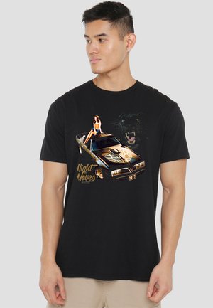 Black t-shirt featuring a graphic of a vintage car with gold accents, model year 1977, and a woman in a swimsuit, with a panther design in the background.