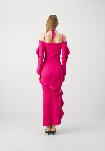 Robe ajustée, côtelée, dénudée d'épaules en rose vif avec des manches longues et un ourlet volé. Présente un nœud à l'encolure à l'arrière.