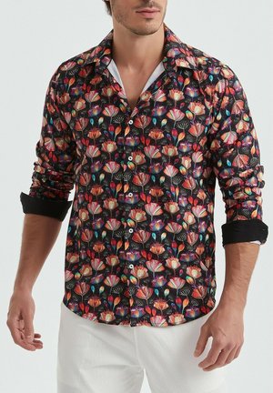 Chemise noire à manches courtes avec un motif floral vibrant en rouge, rose et bleu. Présente un col classique et une fermeture à boutons.
