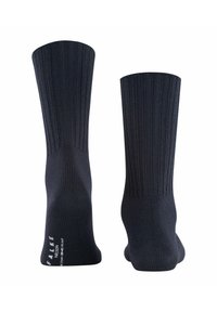 Calcetines oscuros de color azul marino hasta la rodilla con textura acanalada y punta reforzada. Presenta el nombre de la marca impreso en blanco en el lateral. Diseño sencillo y funcional.