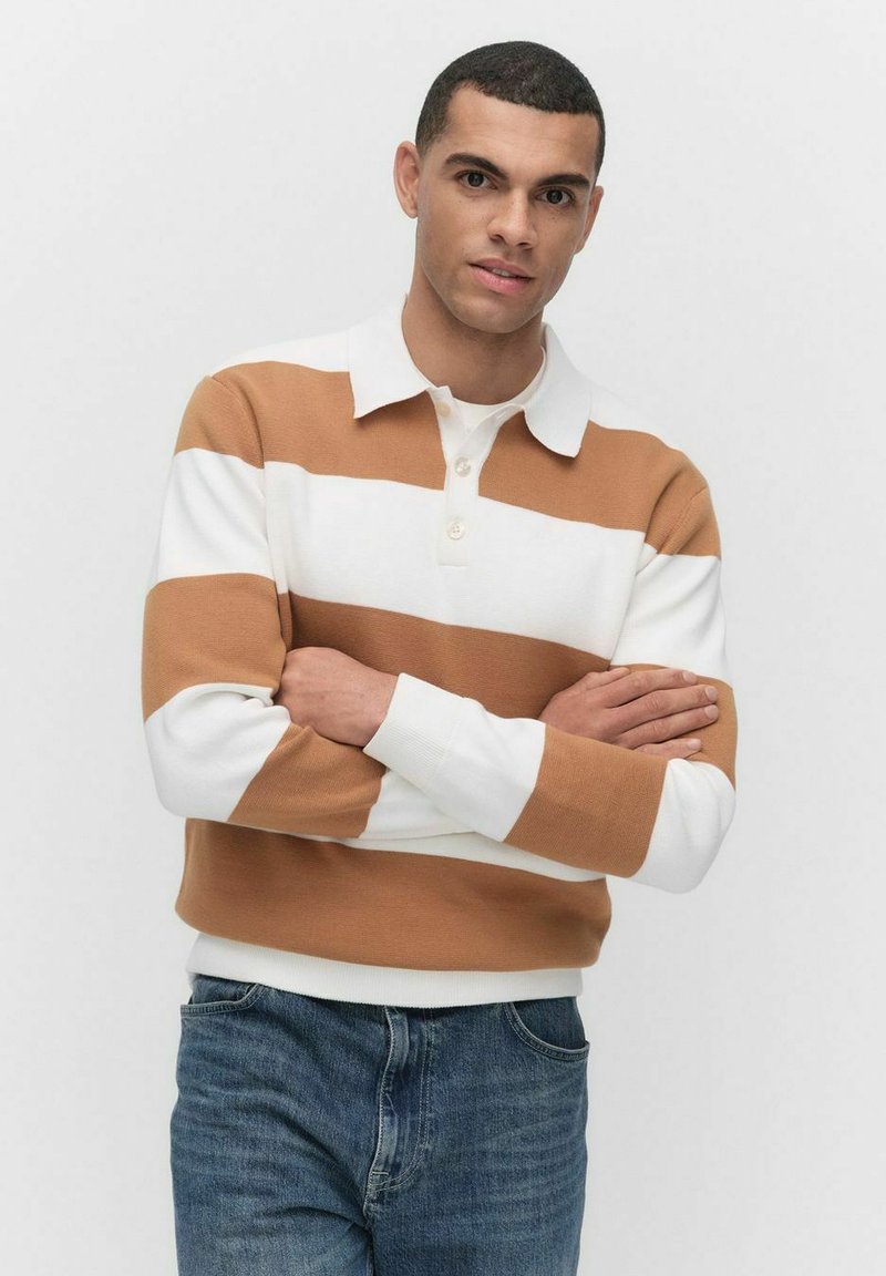 Randig långärmad polo i brun och vit, med krage och knapplist, kombinerad med blå jeans. Slät stickad textur.