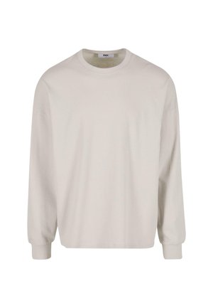 Világos bézs színű, hosszú ujjú pamut póló, kerek nyakkivágással és bordázott mandzsettával, laza szabással és sima textúrával.