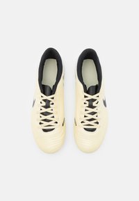 Scarpe da calcio Nike di colore crema con design testurizzato, lacci neri e dettagli. Presentano una linguetta imbottita e un rivestimento interno liscio.
