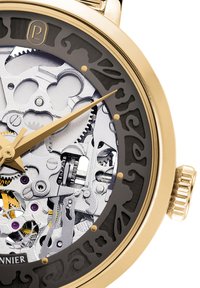 Orologio meccanico color oro con una lunetta nera decorata in modo elaborato. Ingranaggi argentati esposti e accenti viola visibili attraverso un quadrante trasparente.