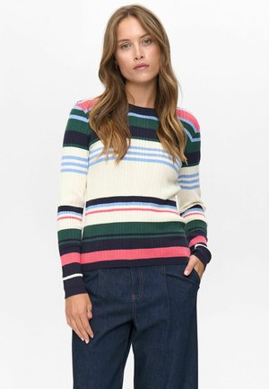 Geribbelde gebreide trui met horizontale strepen in marineblauw, groen, roze en crème. Ronde hals en lange mouwen. Gecombineerd met donkere denim broek.