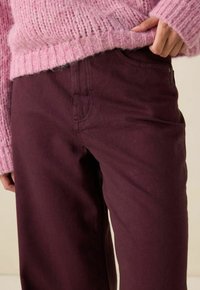 Pantalons bordeaux en mélange de coton, dotés d'un design classique à cinq poches et de détails de couture subtils avec une texture lisse.