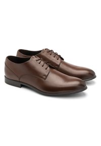 Pantofi de dress din piele maro cu o finisare netedă, vârf rotunjit, design cu șase găuri pentru șireturi și talpă plană din cauciuc.