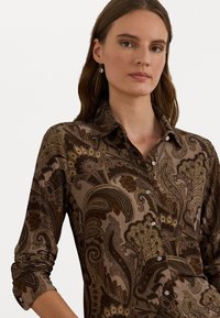 Smeđi košulja s paisley uzorkom, s kragnom, dugim rukavima i prednjim kopčanjem. Izrađena od glatkog materijala s složenim detaljima.