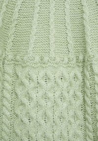 Vaaleanvihreä neulottu kangas, jossa on monimutkaisia palmikkokuvioita ja teksturoituja kudoksia. Pehmeä, pörröinen pinta, jossa on resorikuvio.