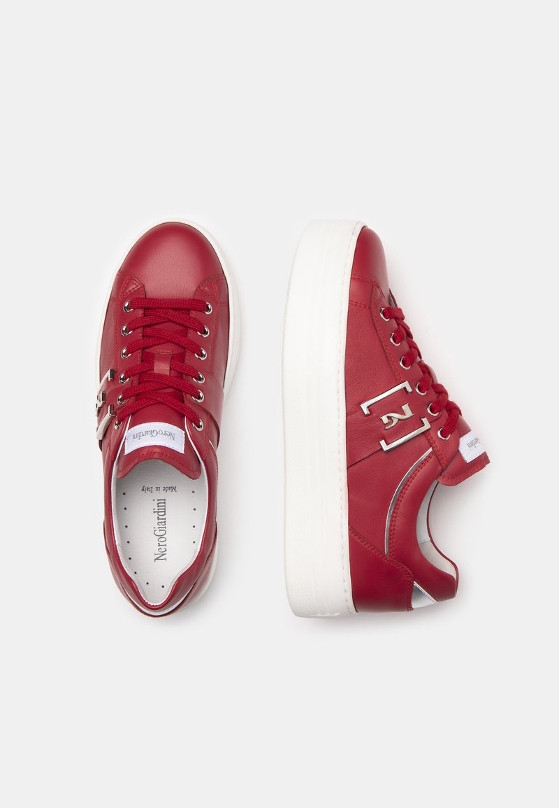 Sneakers in pelle rossa con suole in gomma bianca, dotati di lacci rotondi e dettagli argentati sui lati, che mostrano un design elegante e casual.
