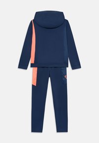 Marineblauwe trainingssuite met capuchon; heeft koraalkleurige accenten op de mouwen en zijkanten van de broek; rekbare stof, aansluitend ontwerp, minimale branding op het been.