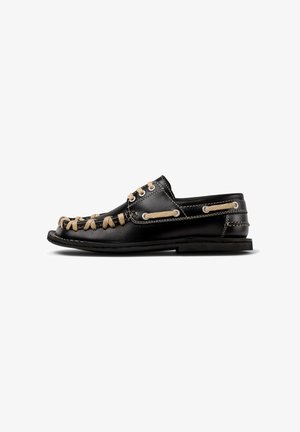 Scarpa nautica in pelle nera con lacci beige a contrasto, dettagli cuciti, suola in gomma e rinforzi in metallo per un supporto aggiuntivo.