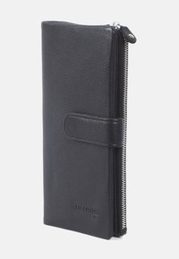 Svart läderplånbok med en texturerad yta, utrustad med dragkedjestängning och magnetisk knapp. Slimmad design med minimal varumärkesprofil.