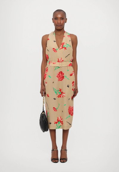 Rochie florală bej cu decolteu adânc în V, cu modele de flori roșii și verzi, talie accentuată cu brâu și lungime până la genunchi; asortată cu accesorii negre.