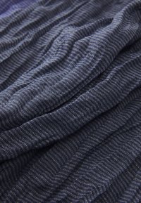Navy blue textured fabric featuring fine white stripes, displaying a soft, rippled surface with alternating, subtle patterns.