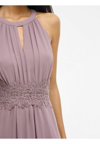 Robe plissée lavande avec un col rond et un détail en trou de serrure. La taille est accentuée par une dentelle intricate pour une touche de design supplémentaire.