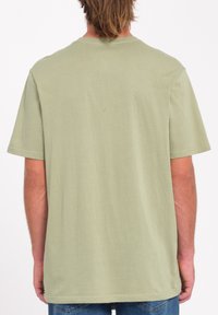 Camiseta de manga corta en algodón verde claro, con un corte relajado y un diseño sencillo que incluye un cuello redondo y un dobladillo recto.