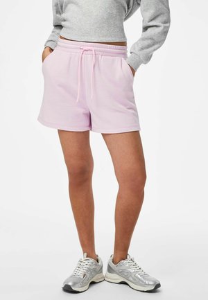 Lyserosa bomullsshorts med elastisk midje og snor, med sidelommer og en avslappet passform, kombinert med sølvfargede sportssko.