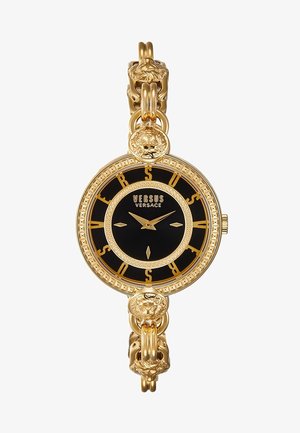 Montre Versus Versace en or avec cadran noir, chiffres romains dorés, détails de tête de lion sur la lunette et les maillons du bracelet, design circulaire.