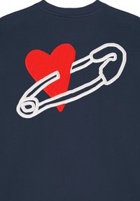 Felpa blu marina con un grande cuore rosso e una spilla di sicurezza bianca ricamata sulla schiena. Tessuto morbido con scollatura a girocollo.