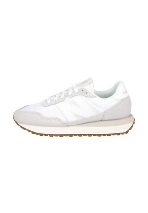 Zapatilla New Balance blanca y gris claro con detalles en ante, diseño con cordones, suela acolchada y suela exterior de goma mostrada de lado.
