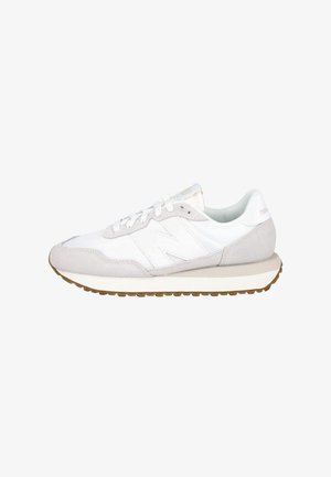 Zapatilla New Balance blanca y gris claro con detalles en ante, diseño con cordones, suela acolchada y suela exterior de goma mostrada de lado.