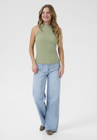 Ljusgrön ribbad ärmlös topp matchad med lösa ljusblå denimjeans. Outfitten har en avslappnad passform och en casual stil.