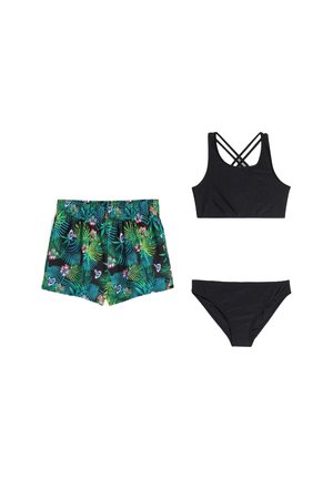 Costume da bagno composto da un top nero con spalline incrociate, uno slip nero e pantaloncini da bagno verdi con motivo floreale tropicale.
