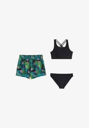 Costume da bagno composto da un top nero con spalline incrociate, uno slip nero e pantaloncini da bagno verdi con motivo floreale tropicale.