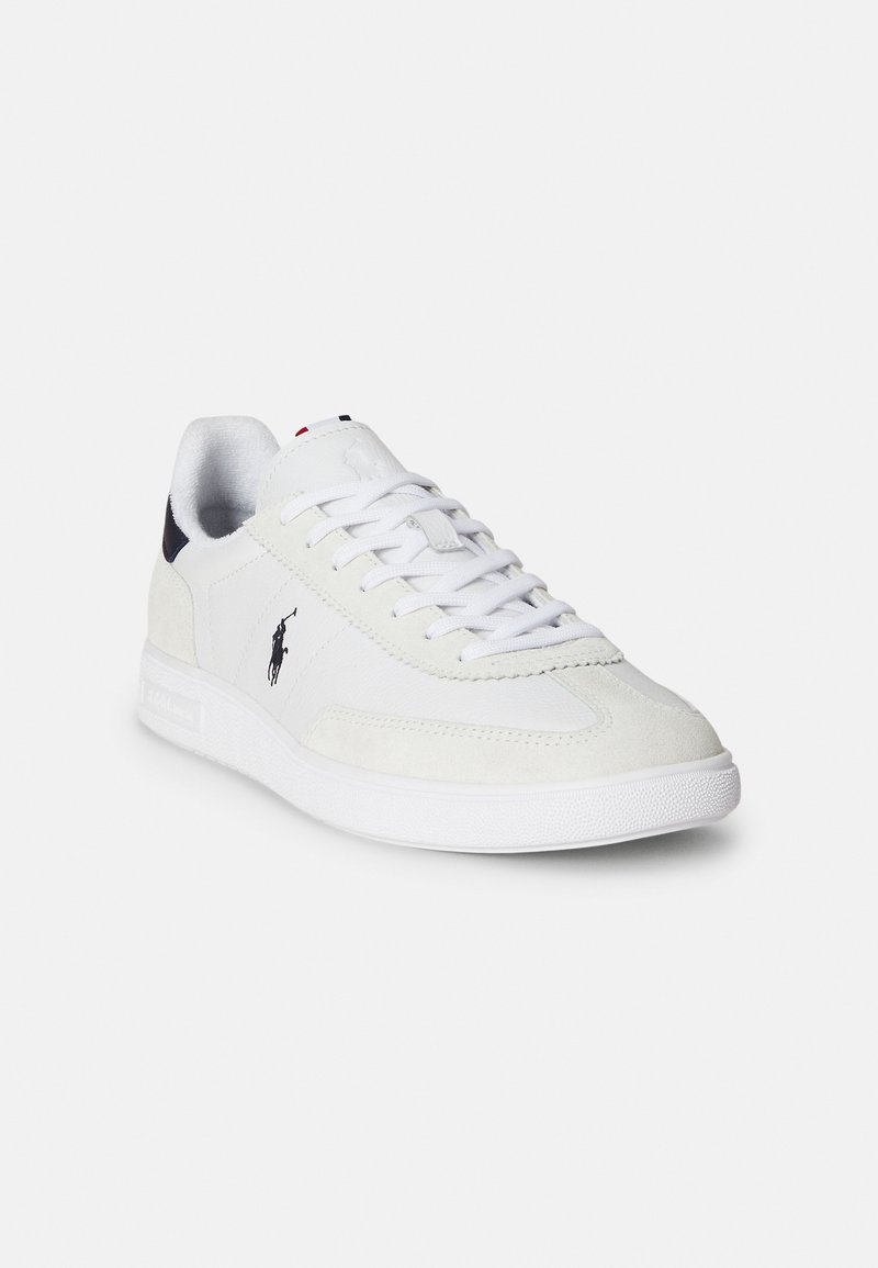 Weißer Sneaker mit Obermaterial aus Wildleder und Leder, strukturierter Zehenkappe, flachen Schnürsenkeln und einem Logo an der Seite. Gummisohle mit Profil.