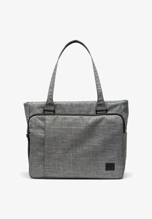 Sac cabas en tissu gris avec longues poignées, poche avant zippée et petite étiquette de marque noire dans le coin inférieur droit.