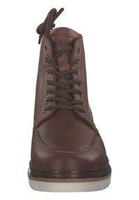 Braune Lederankelstiefel mit runder Zehenpartie, cremfarbiger Gummisohle und braunen sowie beigen gemusterten Schnürsenkeln. Mit Metallöse und genähten Details.