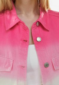 Giacca di jeans rosa con effetto ombré, dotata di colletto a punta, chiusura con bottoni metallici argentati e alette per tasche frontali. Finitura in tessuto testurizzato.