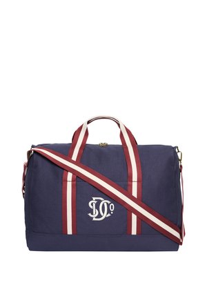 Navy blue duffle bag with red and white striped handles and shoulder strap, featuring white embroidered logo on front.