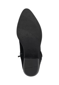 Bota negra de tacón alto con puntera afilada y suela texturizada. Presenta una cremallera lateral y material suave y liso. La suela tiene estrías horizontales.