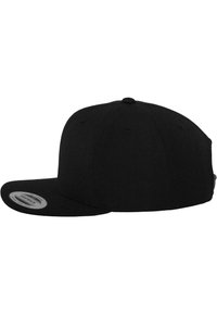 Casquette snapback noire avec une visière plate, design structuré, construction à six panneaux et un petit bouton sur le dessus. Fabriquée à partir d'un tissu durable au toucher lisse.