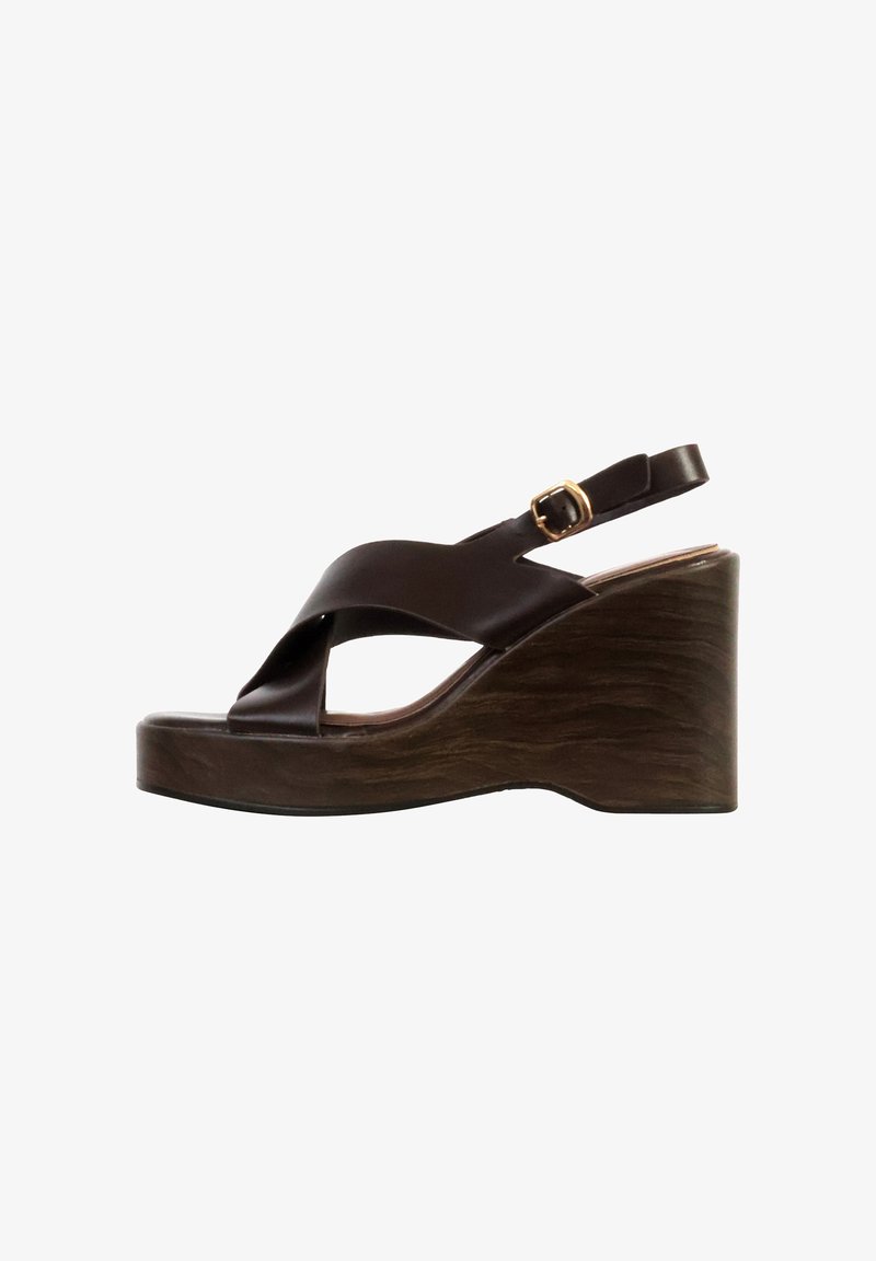 Sandale compensée en cuir marron foncé avec des brides croisées, une boucle dorée et un talon plateforme en bois texturé.
